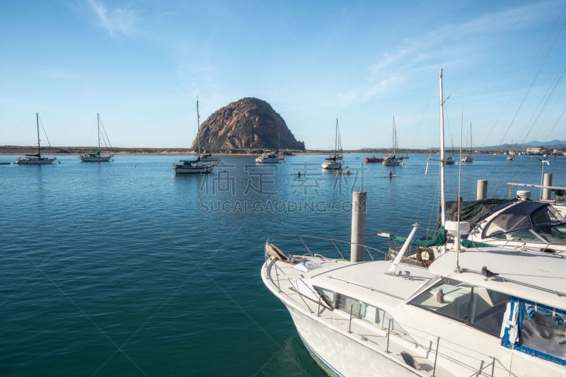 Sailing boats and Morro Rock at Morro Bay, California. The area has become famous for its beautiful state parks, bird estuary’s, and the distinct Morro Rock. Tourists and locals both enjoy a variety of activities in the area, including fishing, surfing, k