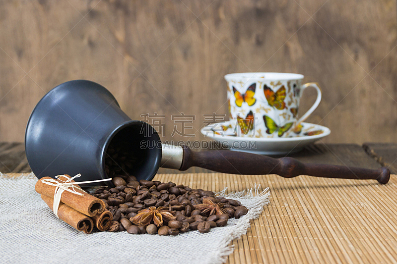 Кофейных зерен, корицы,бадьян и мускатный орех на фоне бамбуковой циновки. Жареный кофе в зернах фон крупным планом.