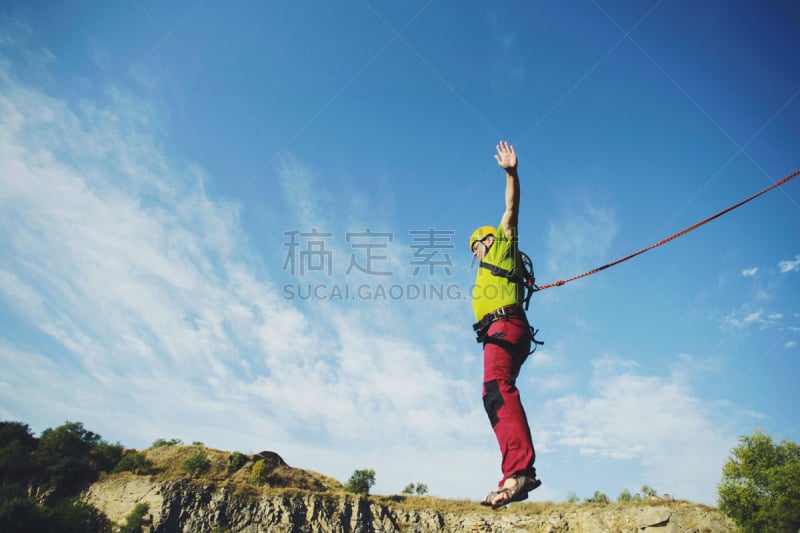 A man jumps into a canyon from a cliff.