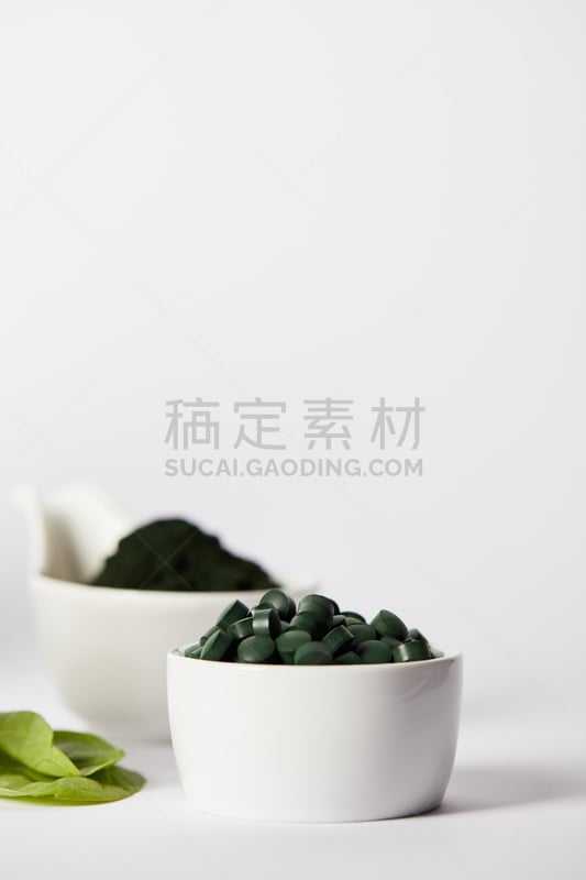 选择对焦,碗,螺旋菌,药丸,灰色背景,研磨食品,叶子,垂直画幅,留白,素食