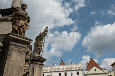 Statues of saints and houses on the square on the Fountain in the piazza in Cesky Krumlov, Czech Republic. Dark and stormy clouds gather around the fountain in the town square, Cesky Krumlov.