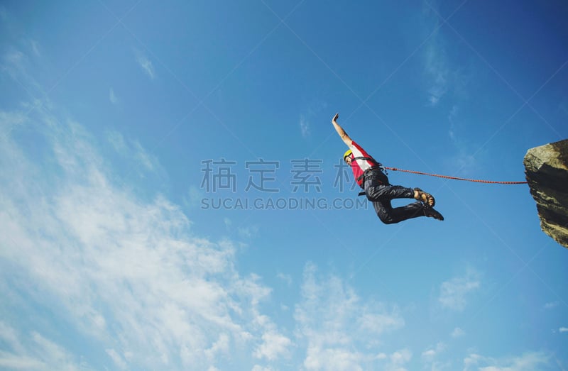 A man jumps into a canyon from a cliff.