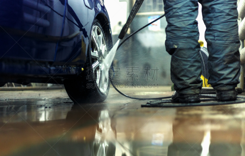 Male washes car of blue color on washing with high pressure