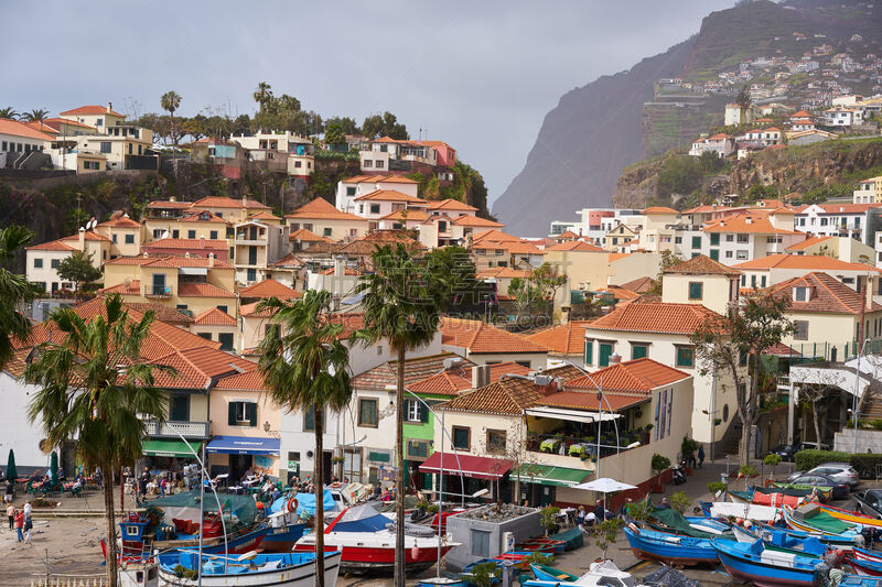 View of Câmara de Lobos in Madeira with Cape Girão on the background and boats at the marina