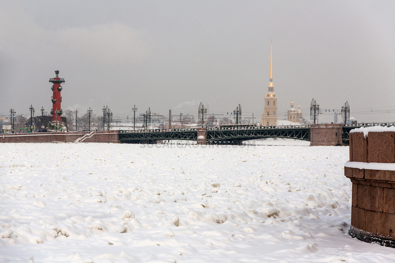 Winter view on Saint Petersburg, Russia, with Palace Bridge, rostral column, Peter and Paul Cathedral in the Fortress and the Neva river covered by ice and snow.