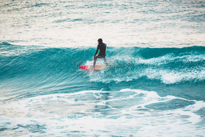 Winter surfing in ocean. Surfer on blue wave