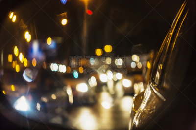 Abstract background of night city traffic jam with car lights through car mirror.