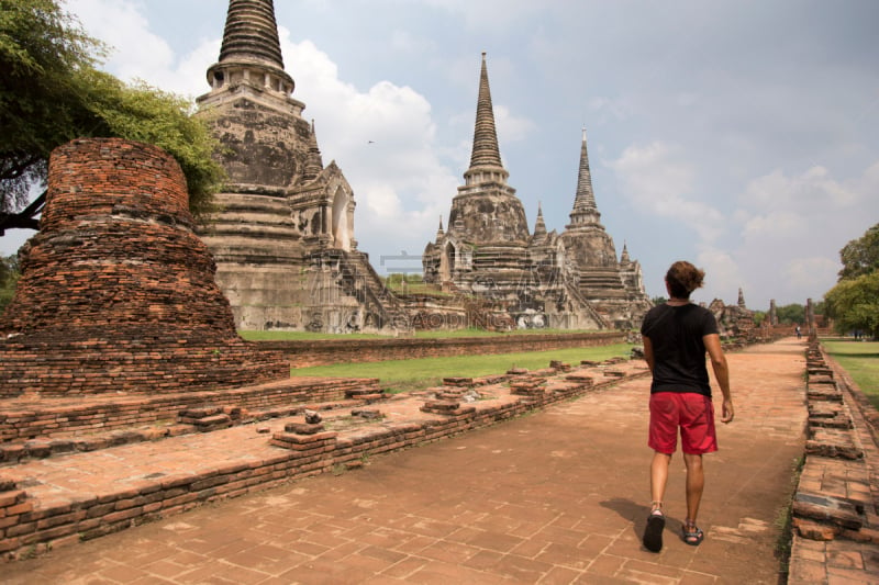 one man, with man bun, visiting the ancient ruins of Wat Phra Si SanphetAyutthaya, Thailand