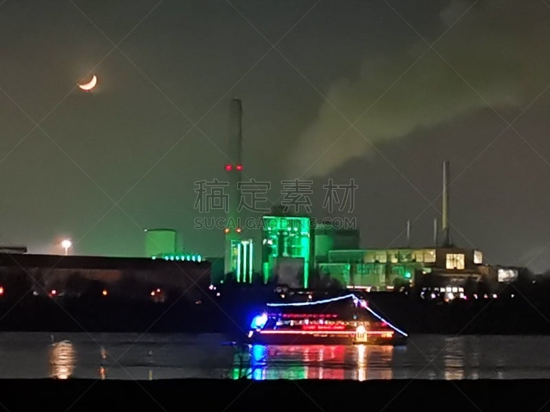 Industrial skyline of Düsseldorf-Neuss-area at night time with new year's eve party boat