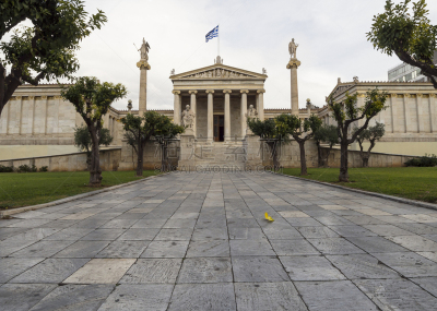 The building of the Athens Academy a marble column with a sculptures of Apollo and Athena, Socrates and Plato against a with clouds in Athens, Greece