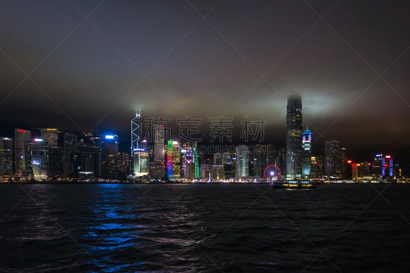 Night view of Hong Kong Central skyline with the top of skyscrapers surrounded by clouds and mist