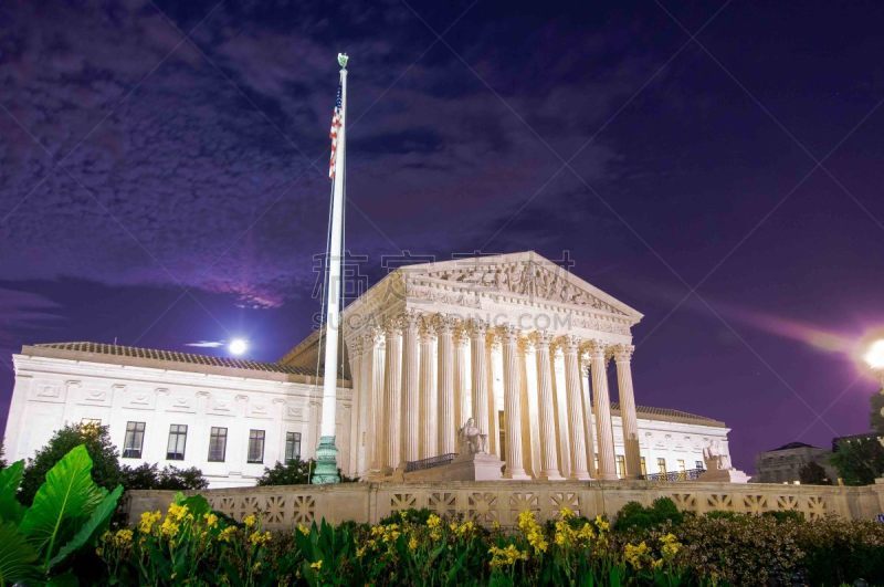 Night time long exposure of United States Supreme Court building in Washington DC with full moon and clouds in background