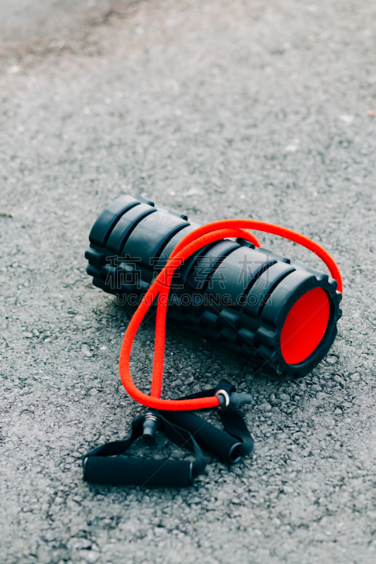 black and red sports roller and elastic band lie on the ground