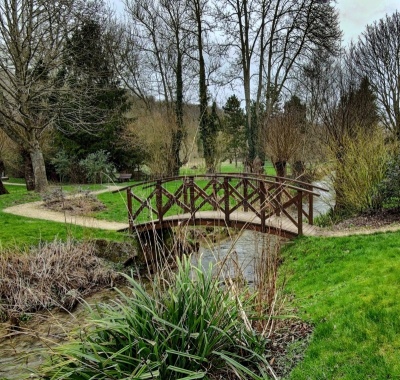 France. Eure. Lyons la Forêt. Petit pont de bois sur la rivière Lieure au milieu de la végétation arborée. Square des Bénédictines. Normandie typique.