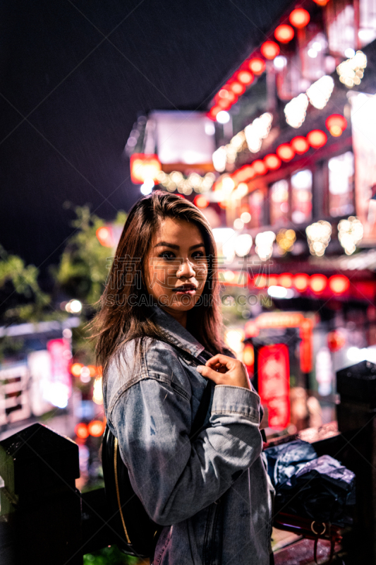 A woman poses on the famous Old Street of Jiufen, Taiwan at night.