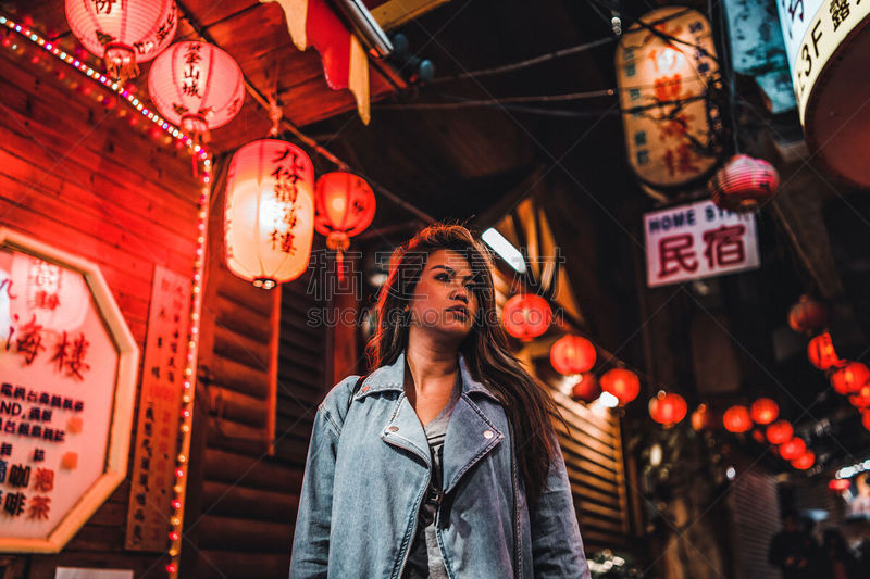 A woman poses on the famous Old Street of Jiufen, Taiwan at night.