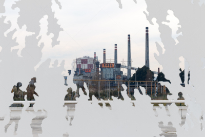 A factory seen behind a public metal sculpture donated from Juan Genovés to the city of Avilés.
