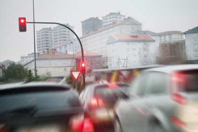 Street view , red traffic lights, cars tail lights, busy city life , stress, Santiago de Compostela. A Coruña province, Galicia, Spain. Cityscape in the background, cars in the foreground defocused.