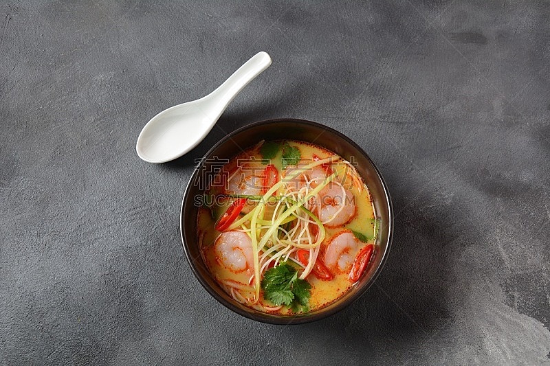 Laksa Soup – a Malaysian Coconut Curry Soup with shrimps over rice noodles topped with fresh bean spouts,cucumber, lime, red chili pepper and cilantro