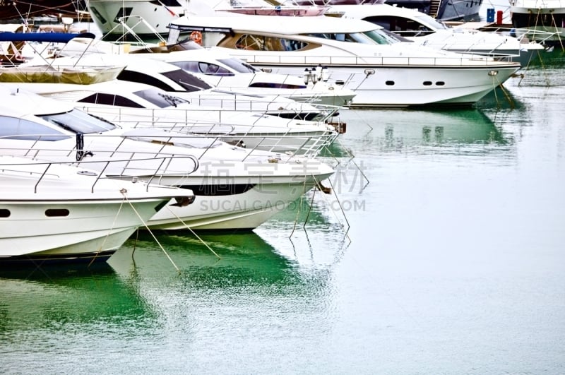 Yachts and speed boats at harbor. Ocean Yachts moored in the port. Ocean Coast pier. High class lifestyle. Yachting. Expensive luxury toys. Sea ​​transport. Nautical Journey. Yachting sport. Expensive white yachts at the pier.