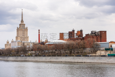A red brick wall factory and  the Hotel Ukraina, or Radisson Royal Hotel, at the bank of the Moskva River, in Moscow, Russia. One the famous seven buildings in Moscow that are known as “Stalinist skyscrapers”.