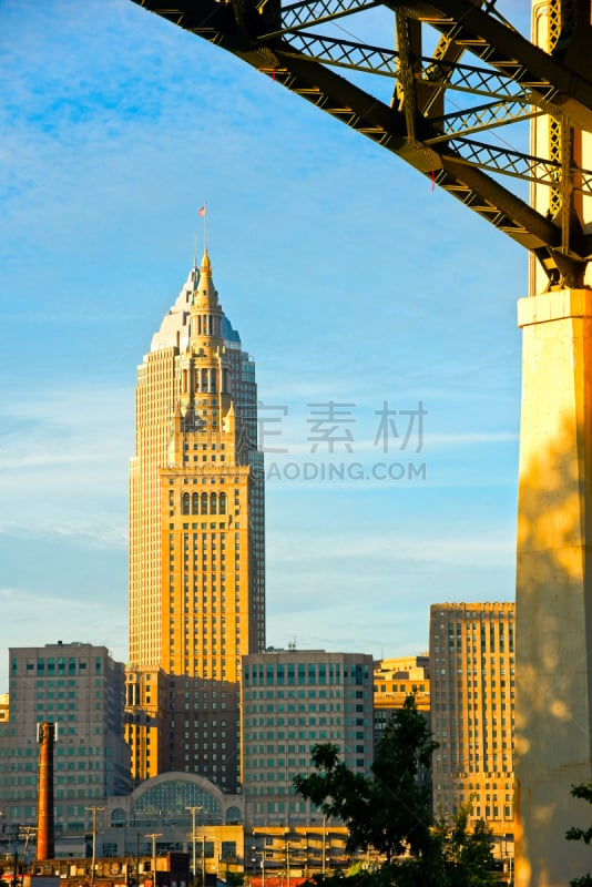 Cleveland Ohioâs tallest two buildings stand as if merged, framed under the steel arch of a highway bridge